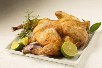Baked tobacco chicken with spices on a plate on