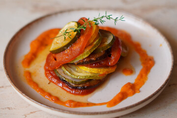 summer vegetable ratatouille with pepper sauce, tricolored zucchini, eggplant and fresh tomatoes - close up