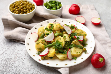 Plate of tasty Potato Salad with vegetables on light background