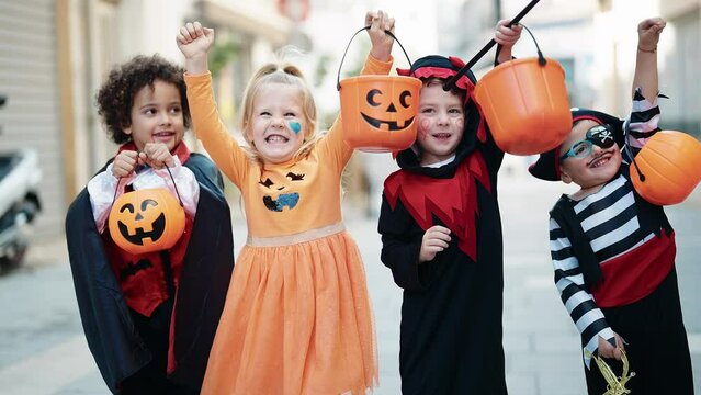 Group of kids wearing halloween costume holding pumpkin basket at street