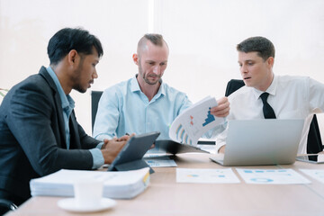 Fototapeta premium Group of diverse business people discussing a project in a meeting for analysis graph company financial.