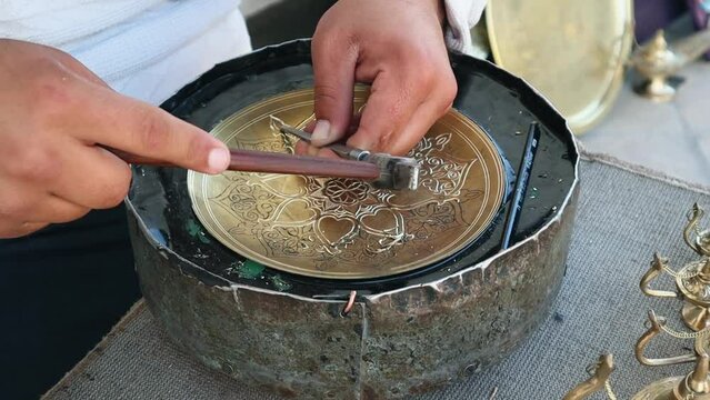 The master engraves patterns on a metal plate. Close-up, handmade, slow motion. High quality Full HD footage