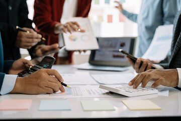 Teamwork process, Business team using a calculator to calculate the numbers of statistic business profits growth rate on documents graph data, desk in the office.