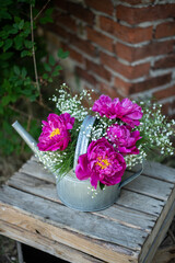 Blumenstrauß mit pinken Pfingstrosen und Schleierkraut, frische Blumen dekoriert in einer alten Vintage Gießkanne aus Metall, Landhaus Dekoration, Bauerngarten