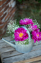 Blumenstrauß mit pinken Pfingstrosen und Schleierkraut, frische Blumen dekoriert in einer alten Vintage Gießkanne aus Metall, Landhaus Dekoration, Bauerngarten