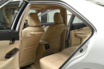 Fototapeta na wymiar The rear passenger seat is wide and clean. Leather interior, side view, solar sunroof, buttons, Nappa leather, beige,black