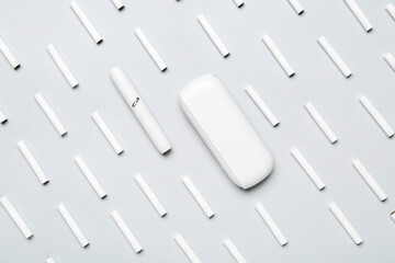 Modern electronic cigar and many sticks on grey background