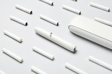 Modern electronic cigar and many sticks on grey background