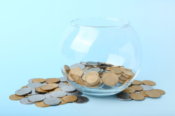 Jar with coins on blue background. Savings concept