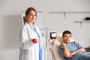 Female doctor with blood pack and heart in clinic