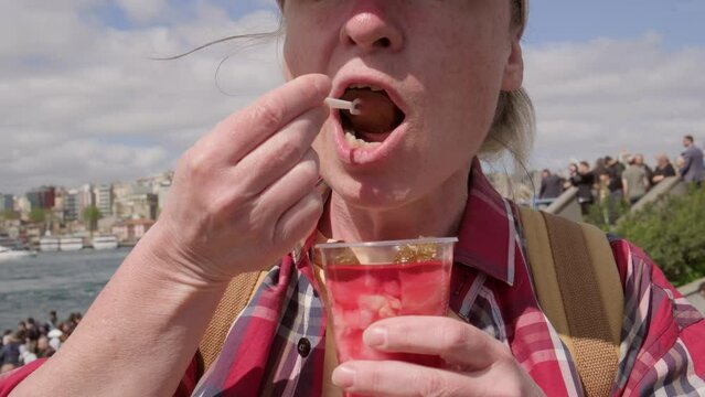 Woman eating pickled cucumbers and cabbage in brine.