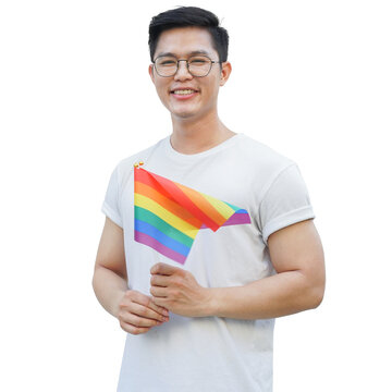 close up adult asian man raise rainbow flag (sign of lgbtq community) and smile with proudly at garden outside for show real personality and support marriage equality on pride month in June concept