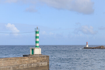 Lighthouses at the entrance to the Bay of Pasaia, Spain. Beacon, pharos, screed, seamark. Ocean bay, sunny, cloudy sky.