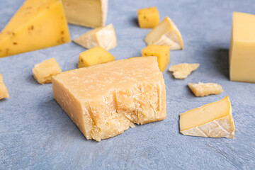 Pieces of tasty cheese on grey background