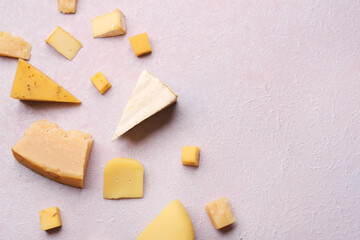 Pieces of tasty cheese on light background
