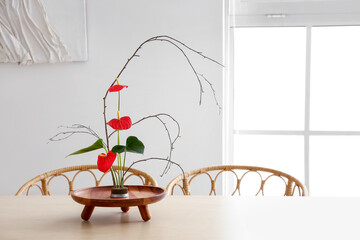 Beautiful ikebana on dining table in room