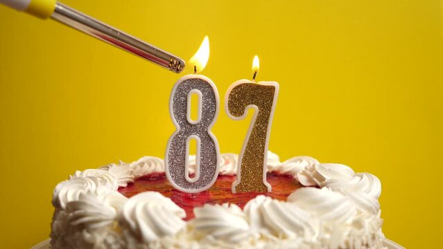 A candle in the form of the number 87, inserted into the holiday cake, is lit. Celebrating a birthday or a landmark event. The climax of the celebration.