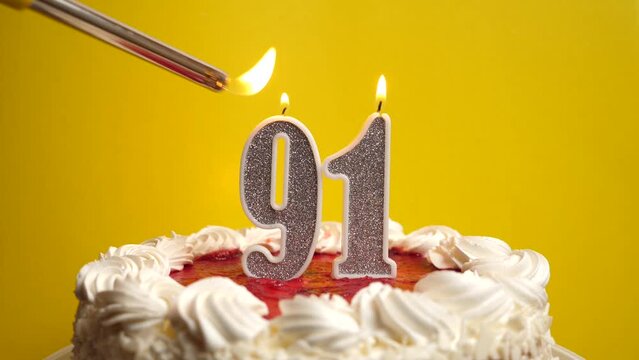 A candle in the form of the number 91, inserted into the holiday cake, is lit. Celebrating a birthday or a landmark event. The climax of the celebration.