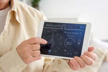 Senior woman with smart home security system control panel, closeup