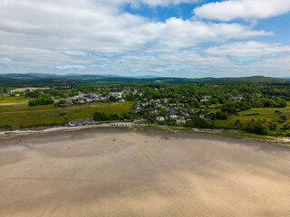 Fototapeta na wymiar This aerial drone photo shows the large beach at Silverdale. Silverdale is a small village at the Morecambe bay, England. There is a low tide and it's summer. 