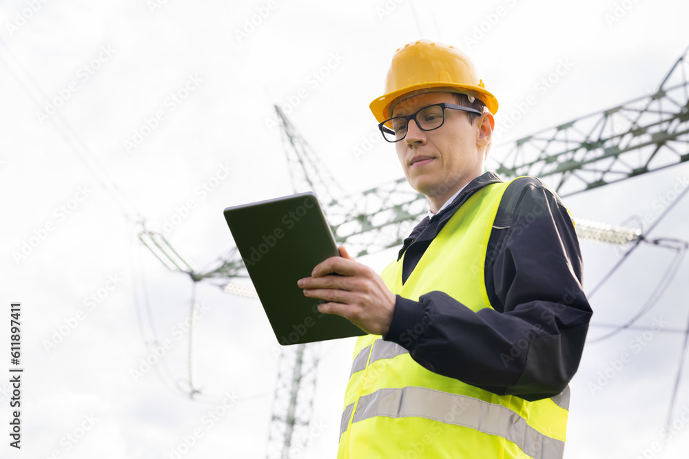 Aufkleber Engineer with digital tablet on a background of power line tower.	