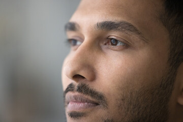 Thoughtful handsome young Indian man facial close up portrait. Face of pensive serious attractive...