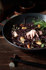 Black funchose with seafood. Close-up, vertical,on wooden background