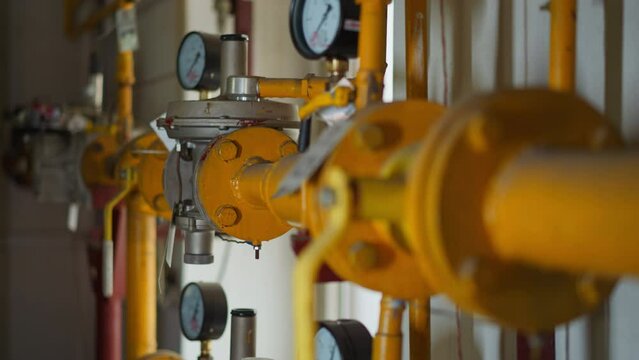 Steel gas transporting pipeline with fittings and pressure meters in mechanical room closeup. Pipes for flammable fuel delivering for water heating