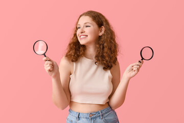 Young woman with magnifiers on pink background