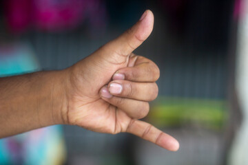 A man shows two fingers of his hand and the background is blurred