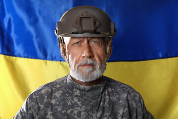 Mature soldier against flag of Ukraine, closeup