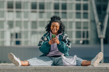 urban girl with mobile phone sitting on the floor