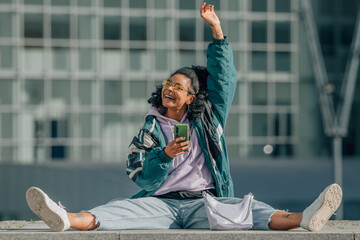 urban girl with mobile phone sitting on the floor