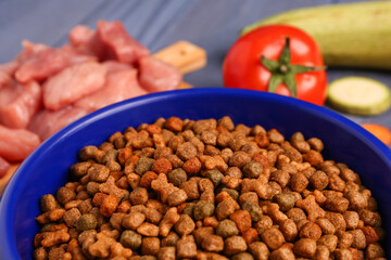 Bowl with dry pet food on table, closeup