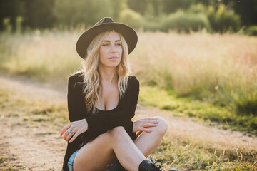 Freedom spirit. American girl at field. Young beautiful woman in Boho black fringe jacket and...