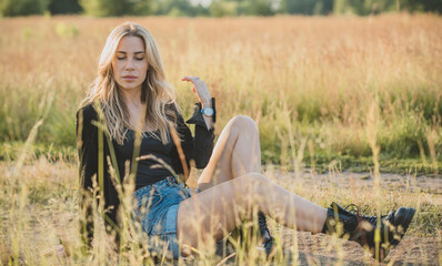 Freedom spirit. American girl at field. Young beautiful woman in Boho black fringe jacket and...