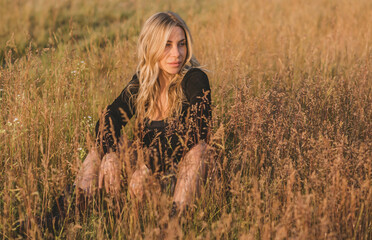 Freedom spirit. American girl at field. Young beautiful woman in Boho black fringe jacket and...