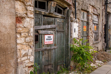 Brama wejściowa do zrujnowanego budynku. Stary zniszczony dom. - obrazy, fototapety, plakaty