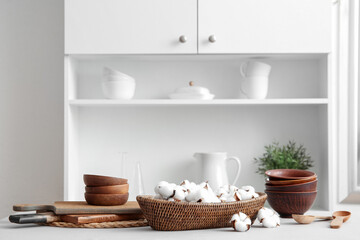 Fototapeta na wymiar Basket of cotton flowers with kitchen dishes on table