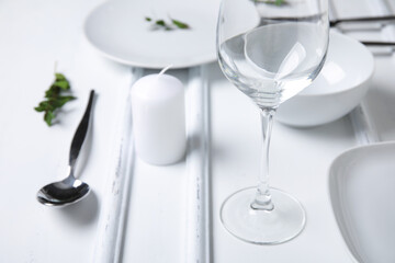 Stylish table setting and candle on white wooden background