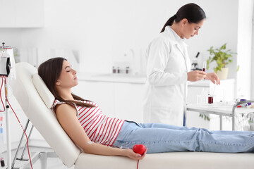 Young woman donating blood in clinic