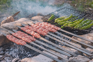 Minced meat kebab frying on a barbeque coals