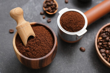 Bowl and portafilter with coffee powder on dark background
