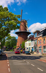 Obraz premium Utrecht, Netherlands-May 02, 2018:Landscape view of ancient street with traditional old mill and houses in Utrecht. Famous touristic place and travel destination in the Netherlands. Sunny spring day