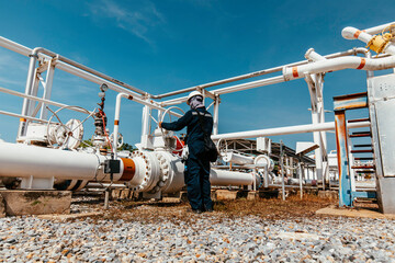 Naklejka premium Production operator opening ball valve at pipeline oil and gas wellhead remote platform to control gases and crude oil process petroleum
