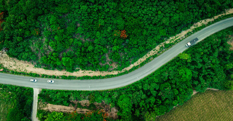 Aerial view of road going through a forest, Road through the green forest, Aerial top view car in the forest