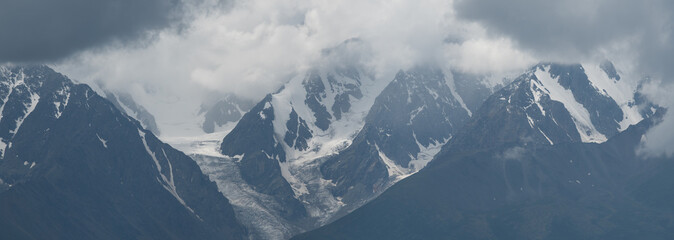 Mountain scenery, snow-capped peaks in the clouds, panoramic view