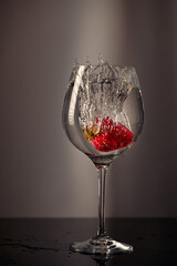 Strawberries dropped into a glass of water.