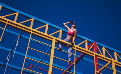 Athletic young woman working out and climbing at the training camp.