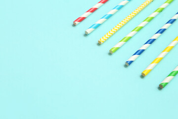 Different paper drinking straws on blue background